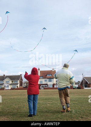 Giovane battenti e guardare stunt kites in visualizzazione sincronizzata su terra dietro crosby fronte mare e il lungomare, crosby liverpool Foto Stock