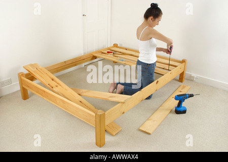 Donna di costruire il telaio in legno bed Foto Stock