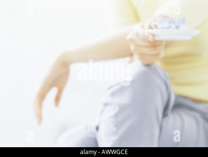 Donna che mantiene tazzina, close-up Foto Stock