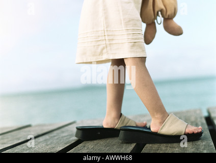 Ragazza di indossare delle calzature femminili, bassa sezione, mare in background Foto Stock