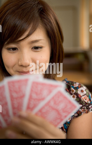 Giovane donna con ventaglio cards Foto Stock