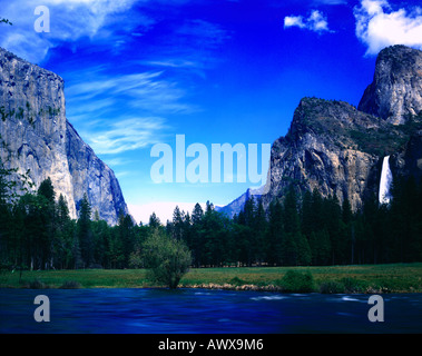 Il fiume Merced pleacefully fluisce attraverso le torreggianti scogliere di granito del Parco Nazionale di Yosemite in California Foto Stock