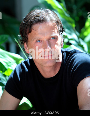 Bello sano uomo di mezza età guardando attentamente nel sole e sorridente Foto Stock