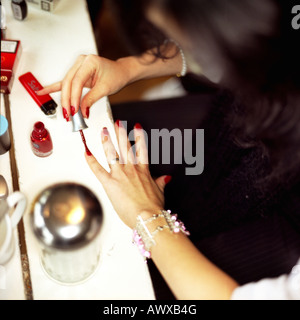 Una donna lacche per unghie di lei con il rosso smalto per unghie Foto Stock