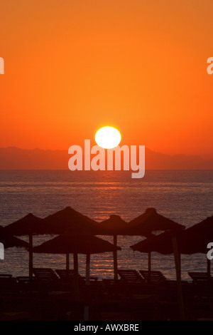 Bellissima alba in Roquetas de Mar in Spagna con paglia ombrelloni sulla spiaggia Foto Stock