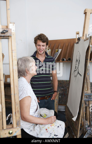 Artista disegno ritratto in studio, giovane uomo cerca su Foto Stock