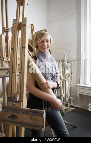 Studentessa piedi tra i cavalletti in art college Foto Stock