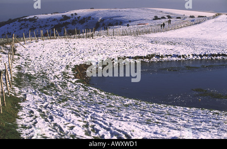 South Downs e neve nei pressi di un laghetto di rugiada a Ditchling Beacon East Sussex Foto Stock