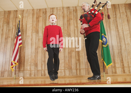 Giovane ragazzo a ballare la musica delle cornamuse Foto Stock