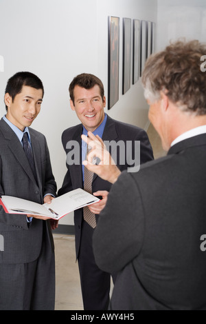 Imprenditori parlando nel corridoio di Office Foto Stock