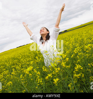 La donna in piedi di Canola Field, Alberta, Canada Foto Stock
