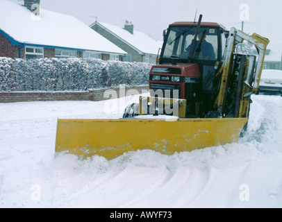 Trattore con un aratro di neve la cancellazione di una strada dopo una tempesta di neve nel nord dello Yorkshire, Inghilterra, Regno Unito. Foto Stock