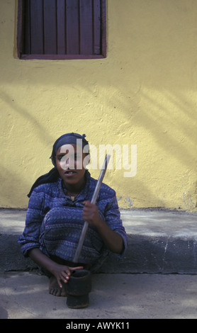 Ragazza macinazione di caffè in legno tradizionale mortaio e pestello, Bahir Dar, Lago Tana, Etiopia Foto Stock