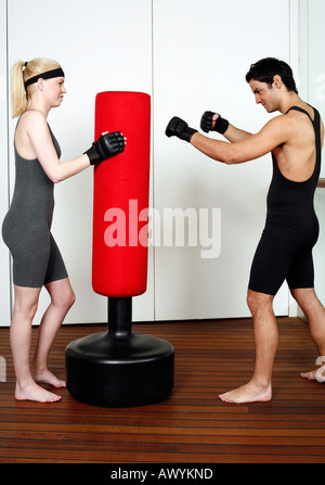 Giovane uomo e donna pratica con un sacco da boxe Foto Stock