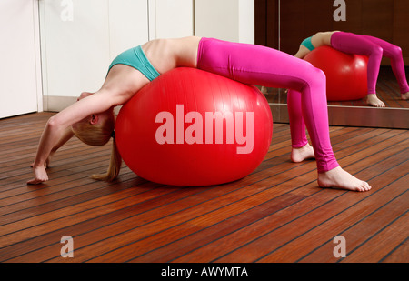 Giovane donna di eseguire un tratto di pilates Foto Stock