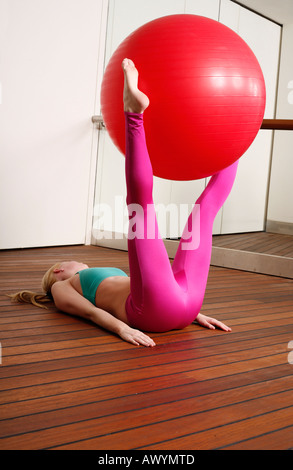 Giovane donna di eseguire un esercizio di pilates Foto Stock