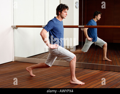 Giovane uomo stretching in palestra Foto Stock