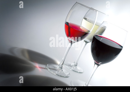 Tre Bicchieri di vino su un bianco classificato sfondo con ombre straordinarie Foto Stock