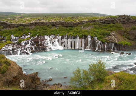 Fiume Hvita invia acqua glaciale fluente attraverso strati di campo di lava a cascata Hraunfossar Islanda Europa Foto Stock