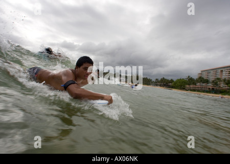 Stati Uniti Hawaii Isola di Kauai Lihue giovane uomo che cavalca boogie boarde sull onda di rottura Foto Stock