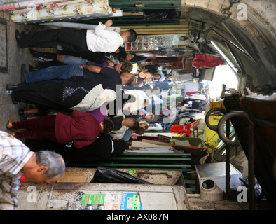 La folla a piedi attraverso un mercato nella città vecchia sezione di Gerusalemme Foto Stock