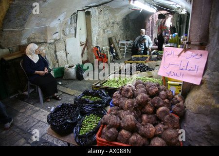 Una donna vendita di olive e di più in un mercato nella città vecchia sezione di Gerusalemme Foto Stock