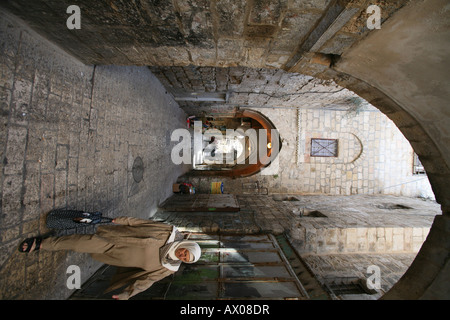 Una donna musulmana passeggiate attraverso un mercato nella città vecchia sezione di Gerusalemme Foto Stock