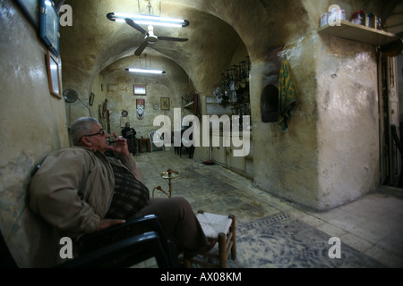 Uomo in un tea shop in un mercato nella città vecchia sezione di Gerusalemme Foto Stock