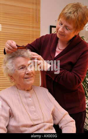 Custode di pettinatura pazienti anziani i capelli Foto Stock