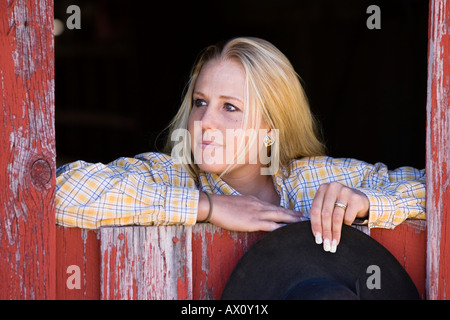 Cowgirl guardando fuori della stalla-finestra, wildwest, Oregon, Stati Uniti d'America Foto Stock