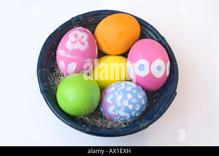 Dipinte a mano e le uova di Pasqua in un blu ciotola di bambù Foto Stock