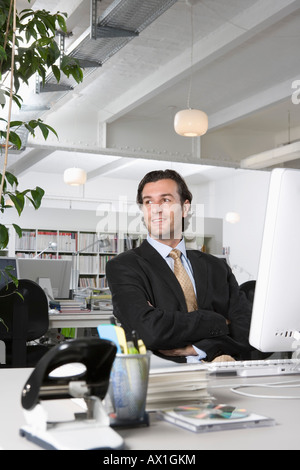 Un imprenditore seduti ad una scrivania in un ufficio Foto Stock