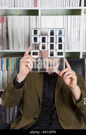 Uomo che guarda un foglio a contatto delle diapositive Foto Stock