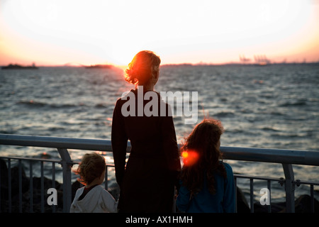 Una madre e due figli che guarda al mare Foto Stock