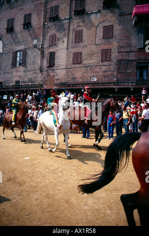 Siena Italia turisti e gente del posto che guarda il Palio di Siena un ippodromo che si tiene due volte l'anno in Piazza del campo ogni fantino rappresenta una delle T Foto Stock