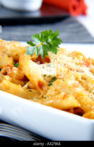 Penne gratinate con pesce e frutti di mare di formaggio grattugiato Foto Stock