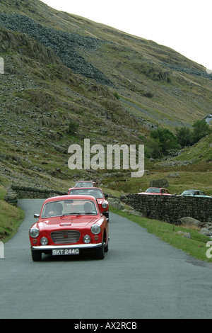 Classic Cars decending Honister Pass, nel distretto del lago, Cumbria, Inghilterra Foto Stock