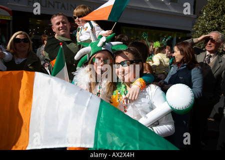 Due giovani ragazze con bandiera irlandese in piedi in attesa della sfilata di carnevale e sul il giorno di san patrizio belfast Irlanda del Nord Foto Stock