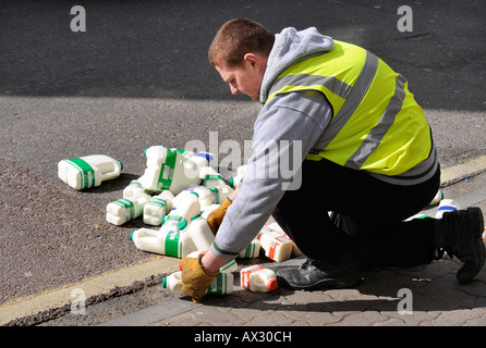 Una pila di contenitori di latte è scesa al di fuori di un Supermercato UK Foto Stock