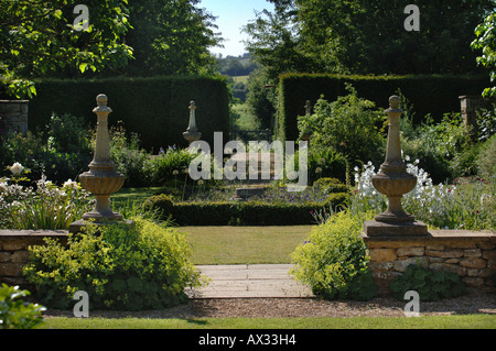 Un percorso fiancheggiato da due colonne in pietra nel giardino di Manor Farm SOMERSET dal progettista di giardini SIMON JOHNSON REGNO UNITO Foto Stock