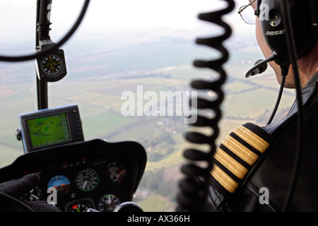 Pilota di elicottero volando sopra la campagna di Wiltshire, Regno Unito Foto Stock