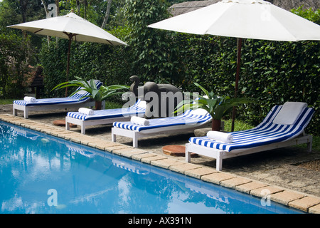 Lettini accanto ad una piscina, Shalimar Spice Garden Resort Hotel, Kumily Kerala, India Foto Stock