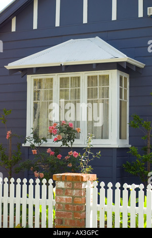 Carino finestra di baia, white Picket Fence e rose su una tipica casa suburbana Foto Stock