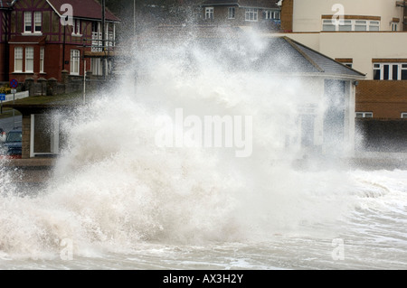 Onde si infrangono la rottura oltre la parete del mare in un giorno di tempesta a baia di acqua dolce fronte mare sull'isola di Wight Foto Stock