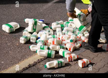 Una pila di contenitori di latte è scesa al di fuori di un Supermercato UK Foto Stock