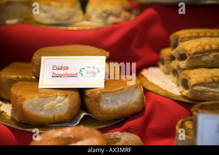 Fudge ciambelle per la vendita in un panificio la finestra di visualizzazione con i prezzi Foto Stock