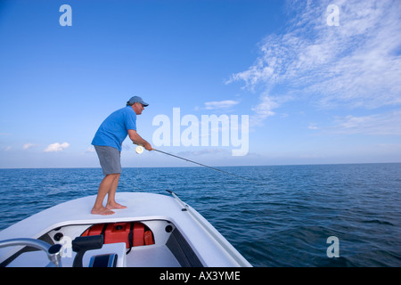 Uomo di Pesca a Mosca Report di pesca per Tarpon off di piccoli appartamenti barca a Key West, Florida, Stati Uniti d'America. Foto Stock