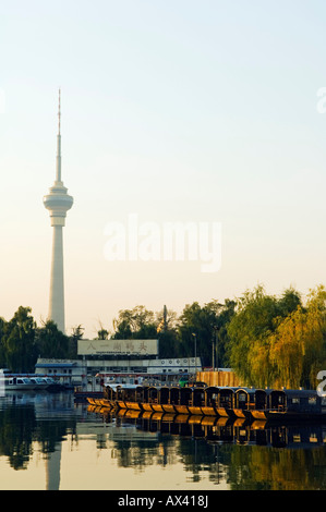 Cina, Pechino. Il CCTV (Televisione della Cina Centrale) torre e imbarcazioni al Yuyuantan Park. Foto Stock