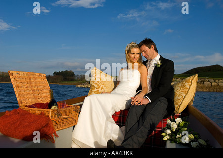 Regno Unito e Irlanda del Nord, Fermanagh, Enniskillen. Sposa e lo sposo andando via in una barca sul lago durante il loro matrimonio. Foto Stock