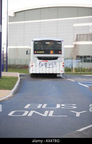 Un colpo di una strada segnata "bus" solo in primo piano con un bus a distanza Foto Stock